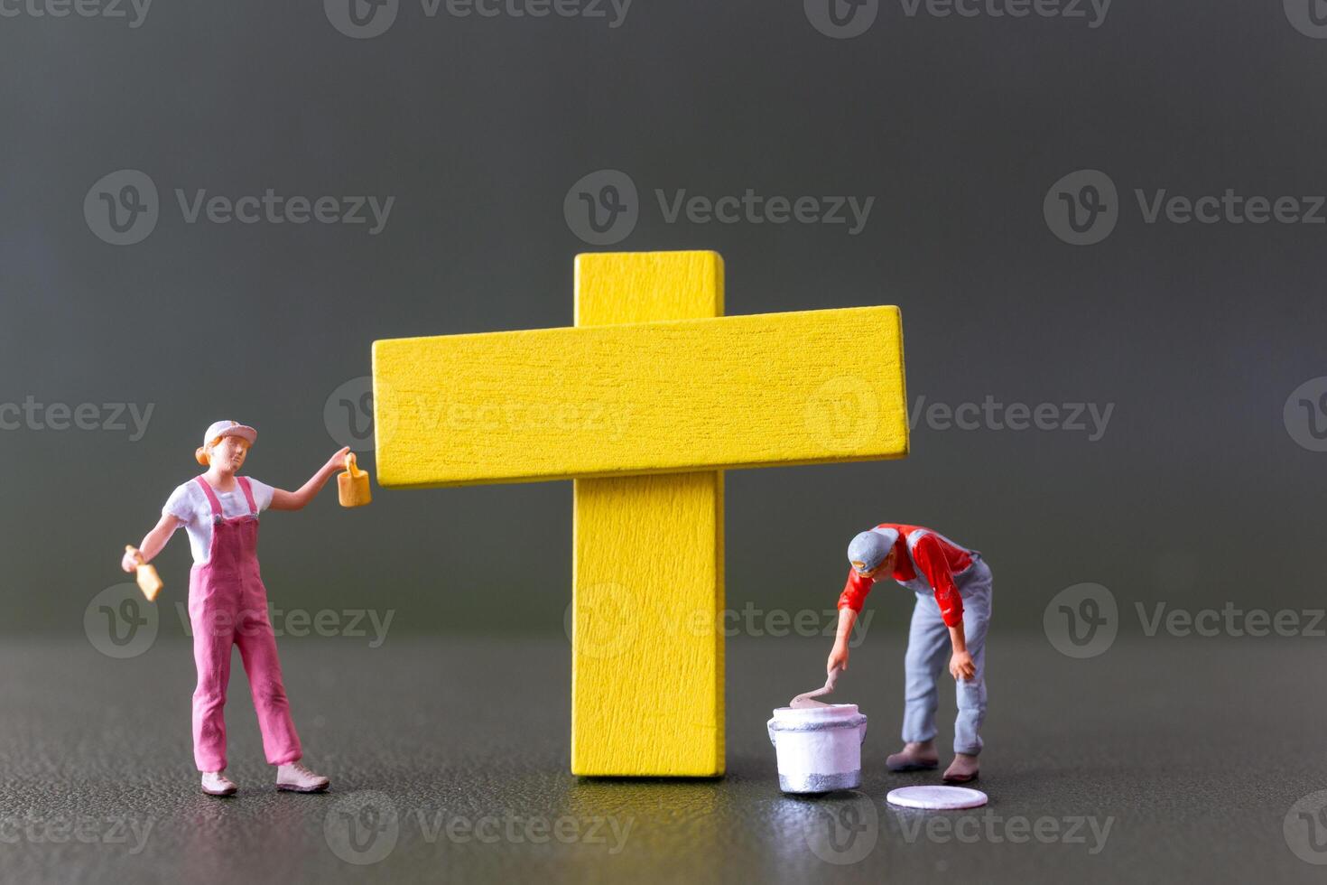 mooi zo vrijdag concept, miniatuur mensen, een geel kruis geschilderd door een artiest foto