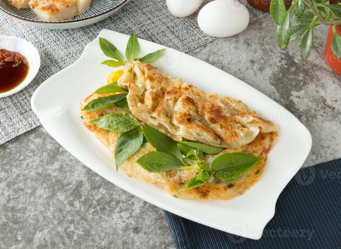 basilicum met ei en lente-ui pannenkoek crackers inpakken geserveerd in schotel geïsoleerd Aan servet top visie Aan tafel Taiwan voedsel foto