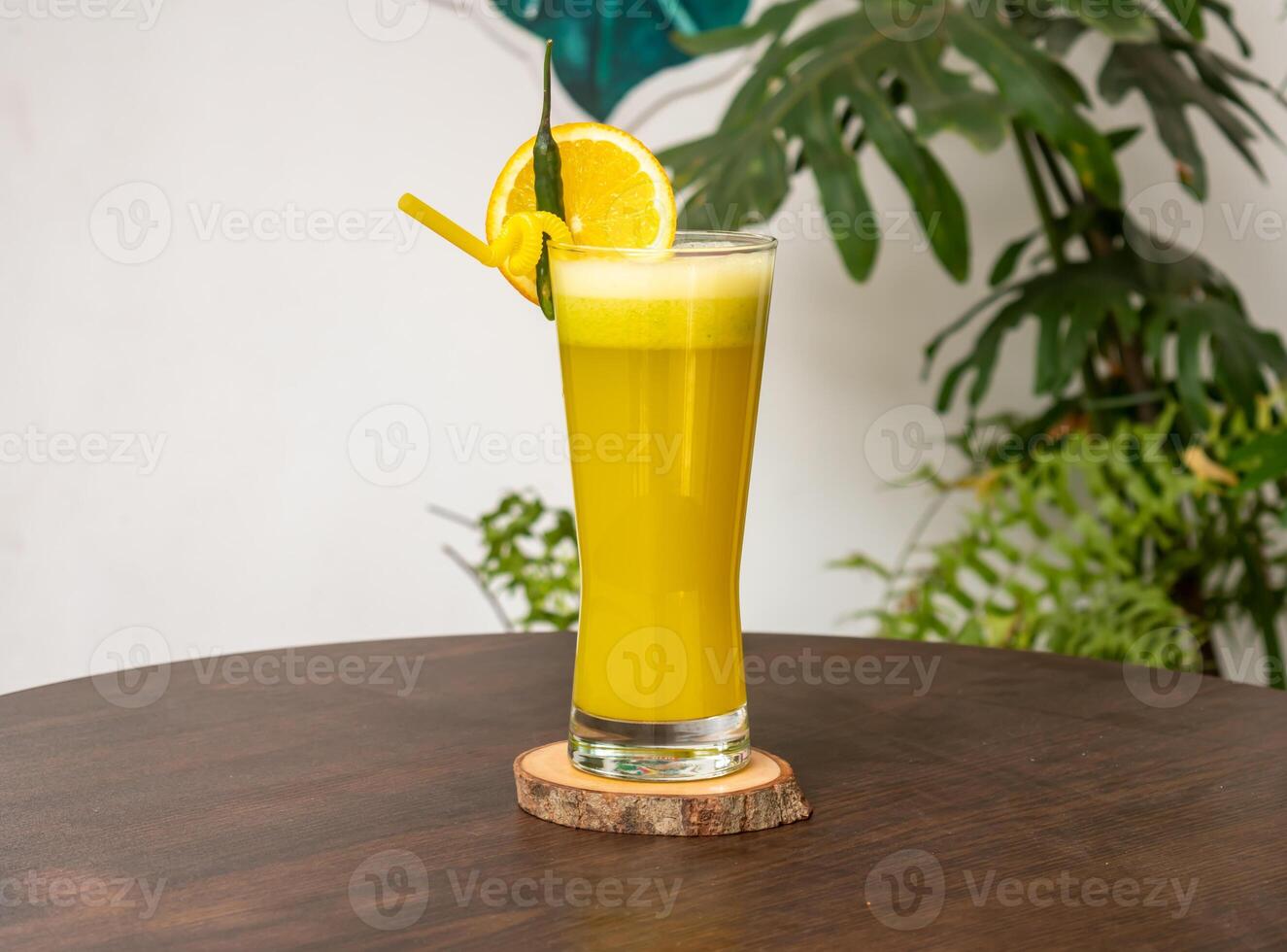 een glas van oranje sap met oranje plak en rietje geïsoleerd Aan houten tafel kant visie gezond drinken voor vitamine c foto