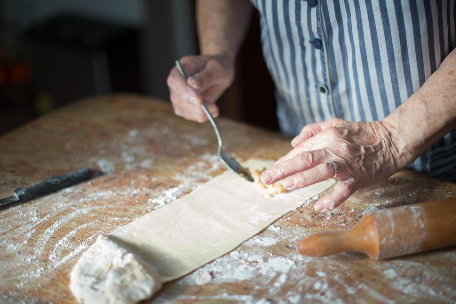 typisch Asturisch kerstdessert. oude vrouwenhanden die de notenvulling op het zelfgemaakte deeg voor casadielles zetten. gastronomie foto