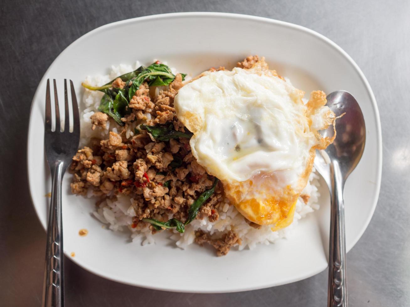 lokale Thaise rijst gegarneerd met roergebakken varkensvlees basilicum en gebakken ei. foto