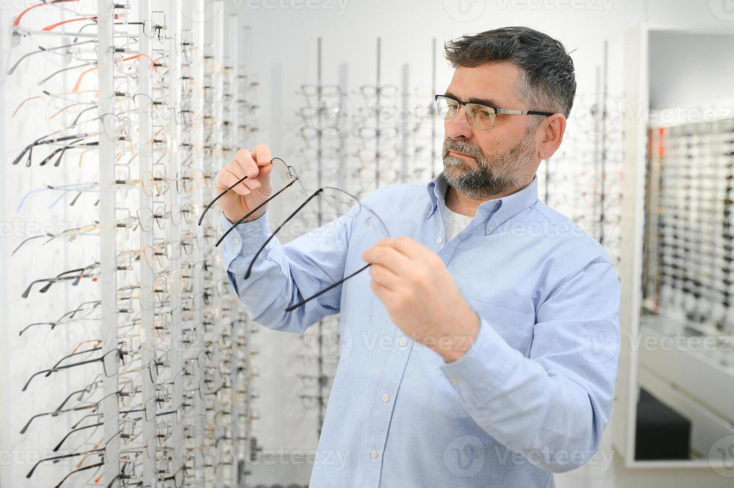 bril controleren, senior visie en ouderen Mens Bij een overleg plegen optometrie kliniek voor welzijn. Vrolijk, glimlach en oud gezicht met lens, kader en eyewear keuze in een op te slaan voor helpen krijgen een recept. foto