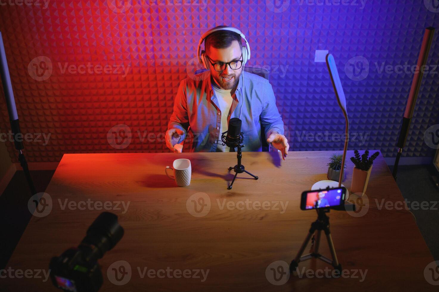 jong Mens opname of streaming podcast gebruik makend van microfoon Bij zijn klein uitzending studio. inhoud Schepper. foto