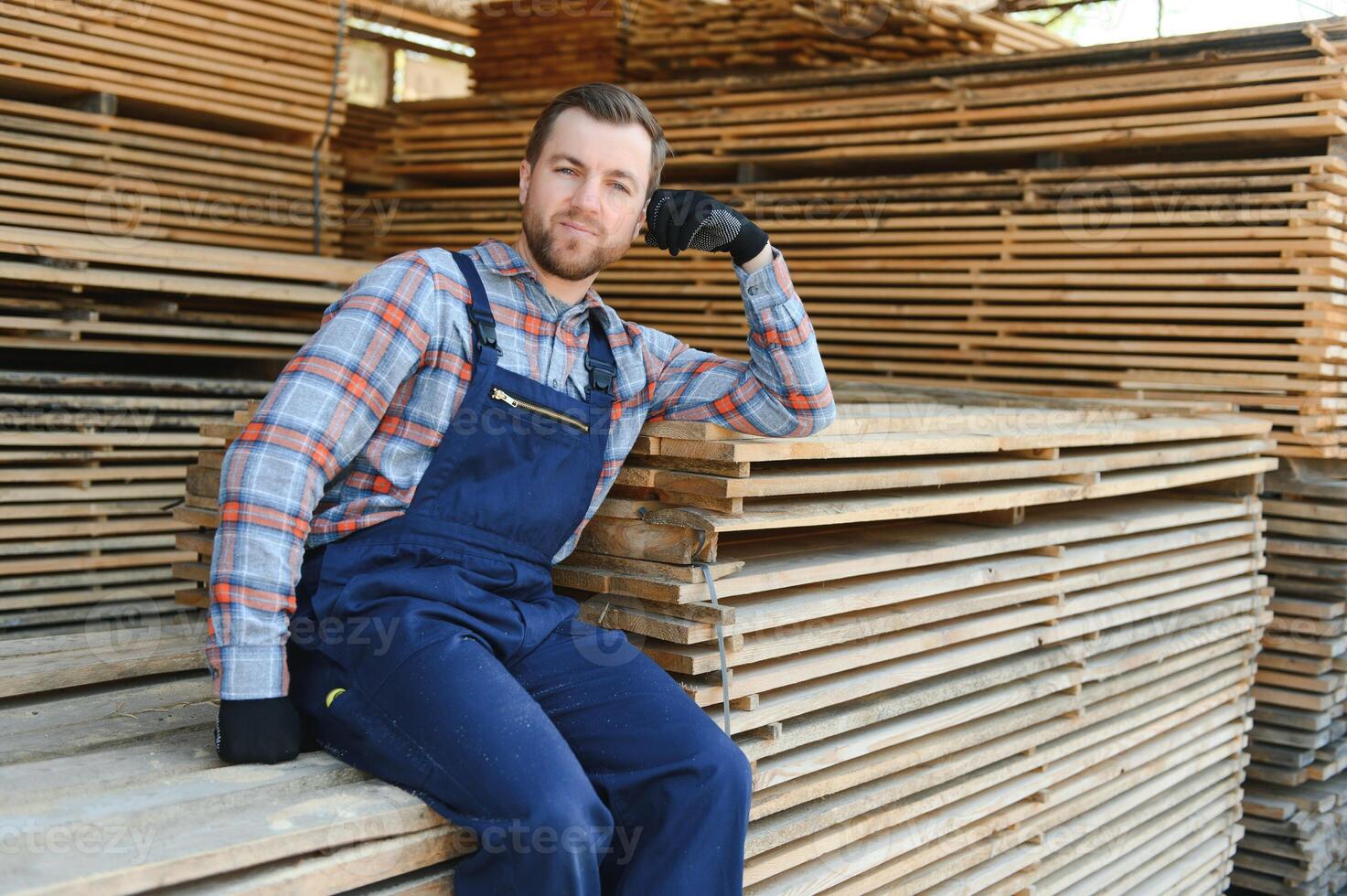 mannetje arbeider vouwen planken. zagerij. hout oogsten werkwijze foto