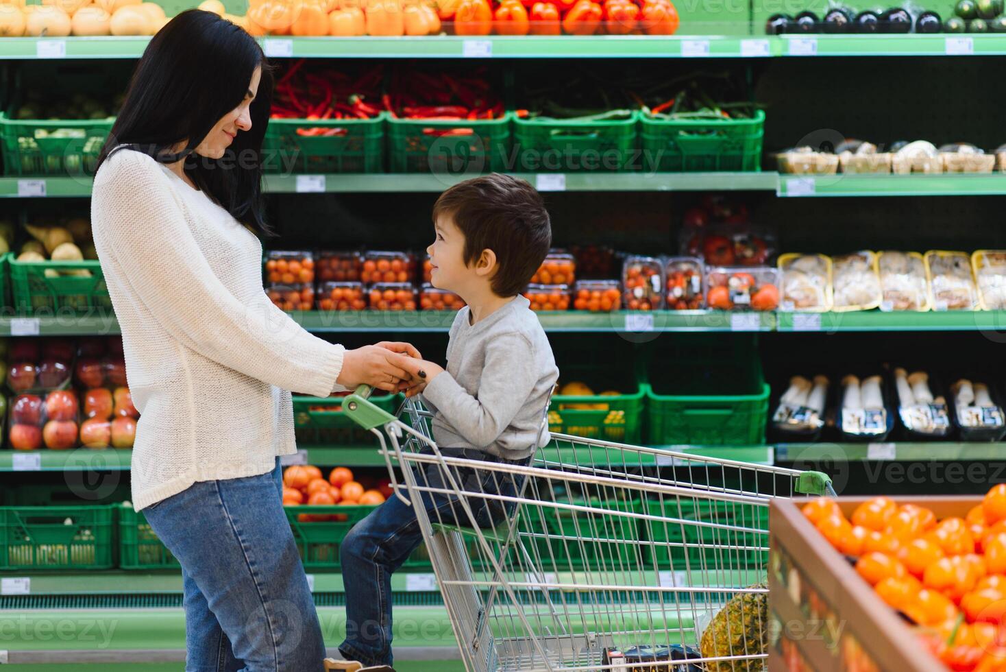 moeder en haar zoon buying fruit Bij een boeren markt foto