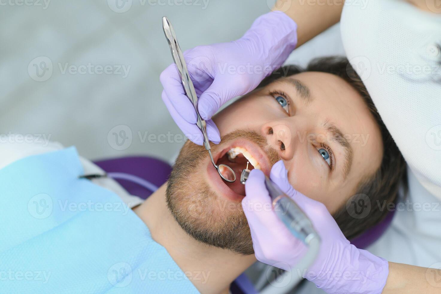 man met tanden onderzocht bij tandartsen foto