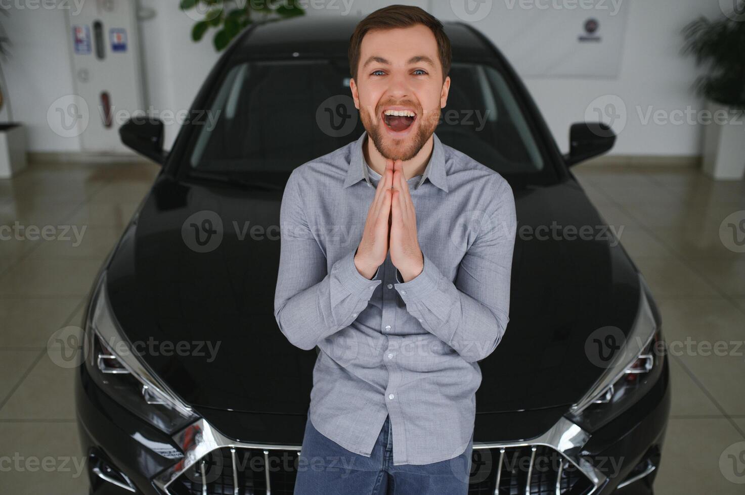 bezoekende auto dealerschap. knap gebaard Mens is strelen zijn nieuw auto en glimlachen foto