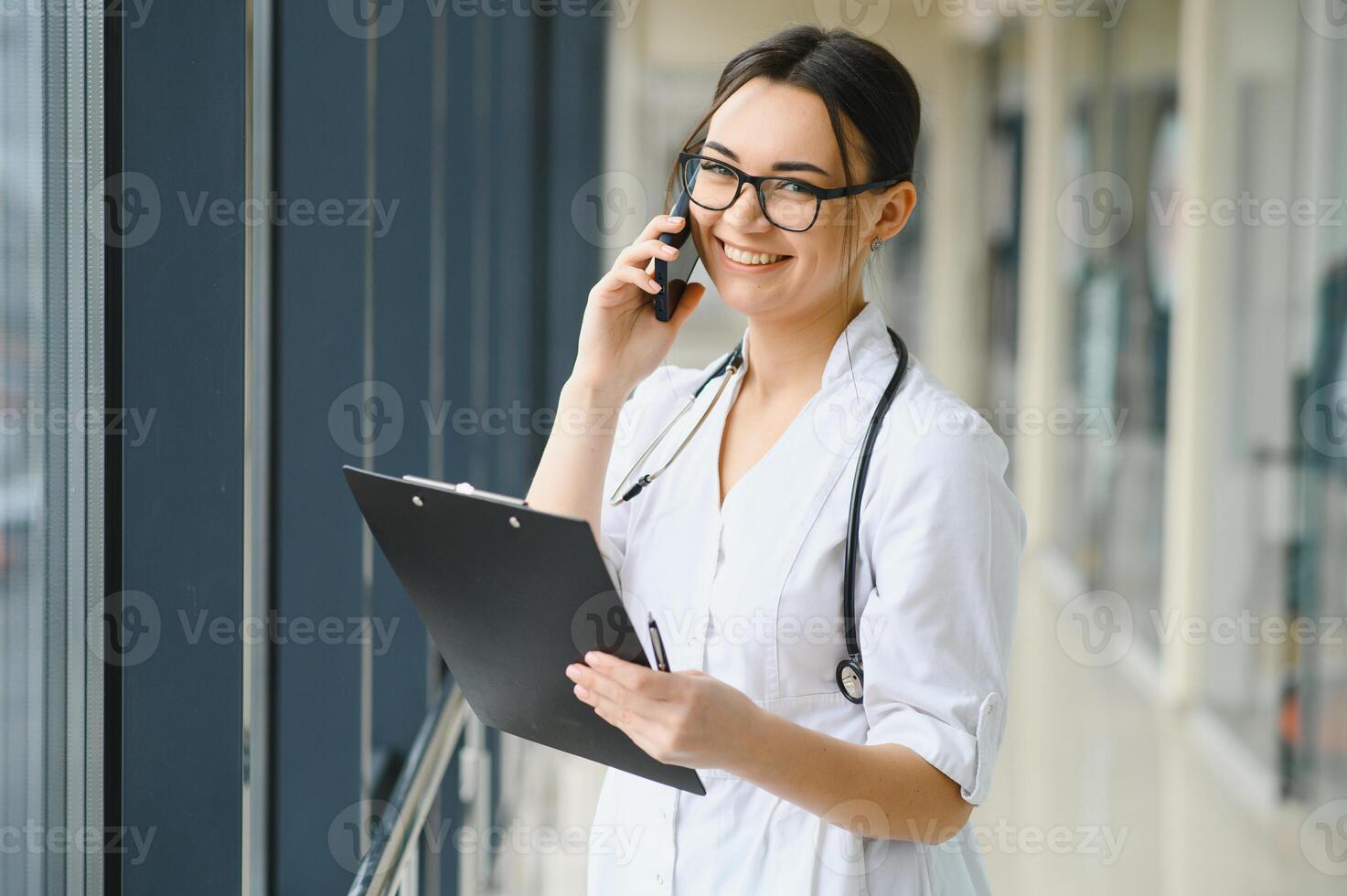 portret van jong vrouw dokter staand in ziekenhuis hal. Kaukasisch vrouw werken in verpleging huis. foto