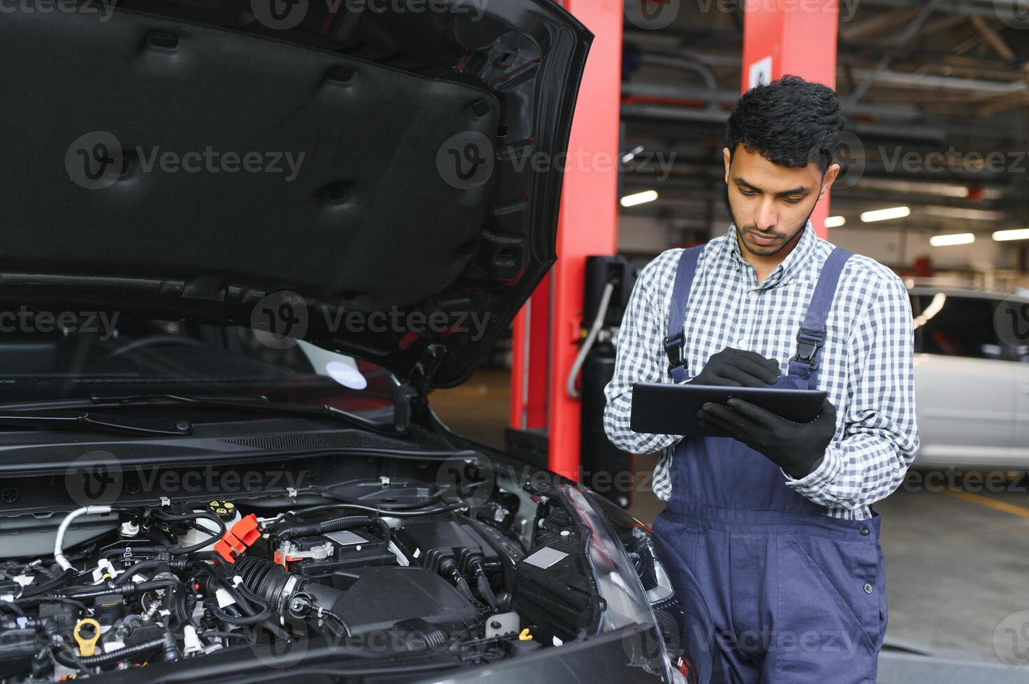 Mens auto technicus monteur repareren auto probleem van motor, gedurende systeem controle detail, gebruik makend van tablet computer voor onderhoud en vaststelling in auto garage. foto