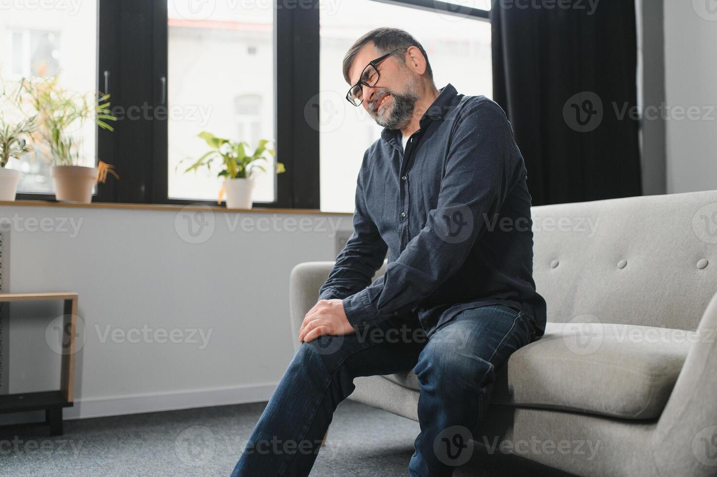 senior Mens lijden van pijn in knie Bij huis foto