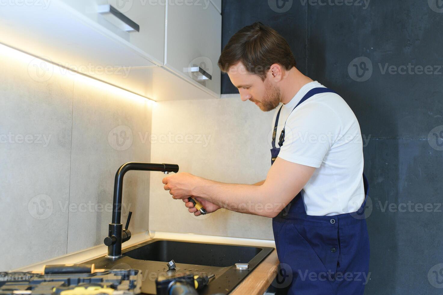 professioneel loodgieter vaststelling water kraan in keuken foto