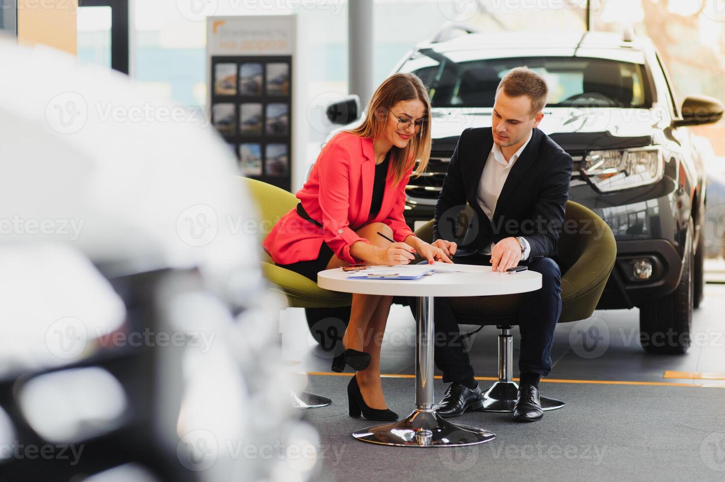 mooi jong vrouw koopt een auto in de handel salon. foto