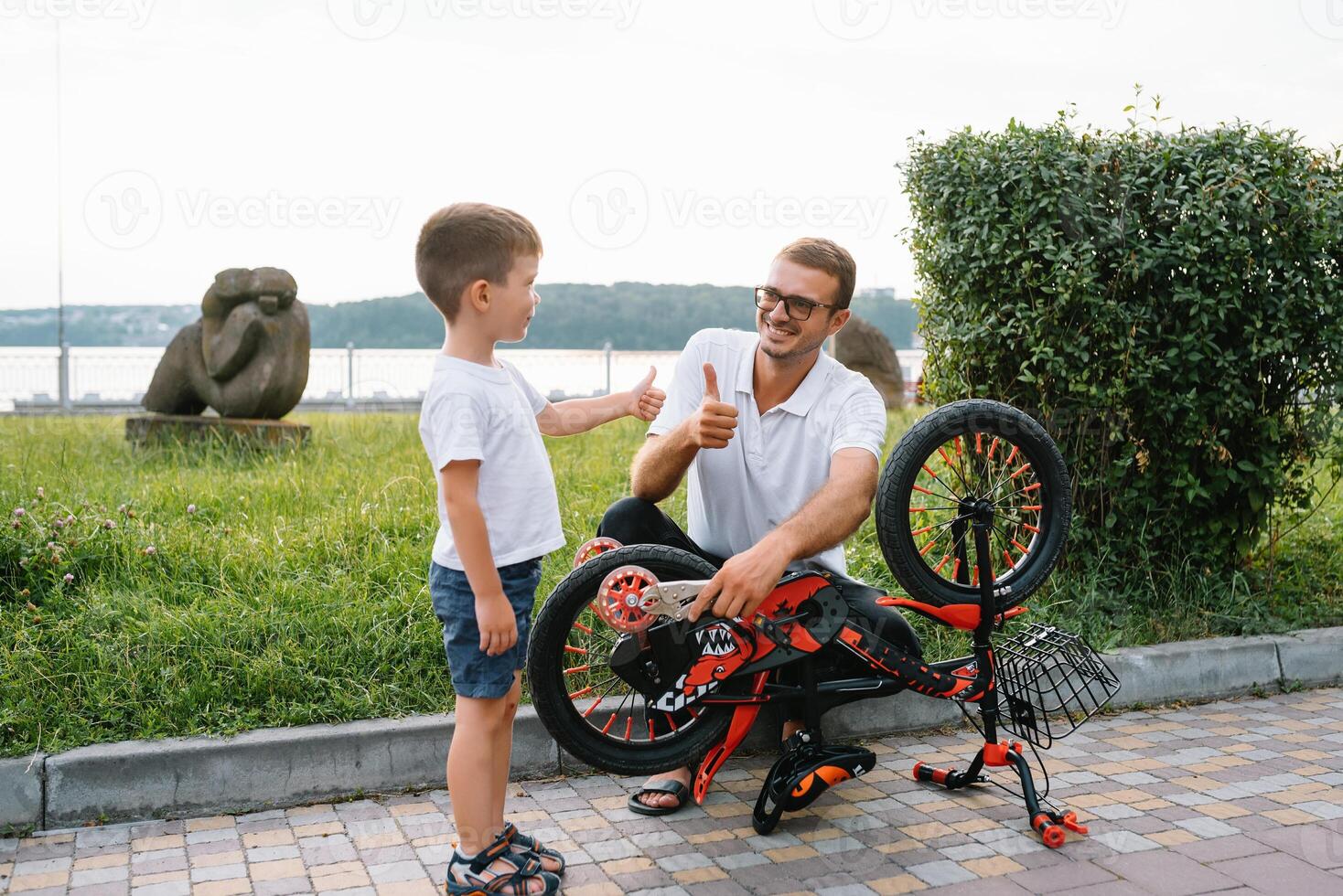 gelukkig vader en zijn zoon hebben pret samen Bij de groen park, vaststelling fiets samen. vader dag. foto