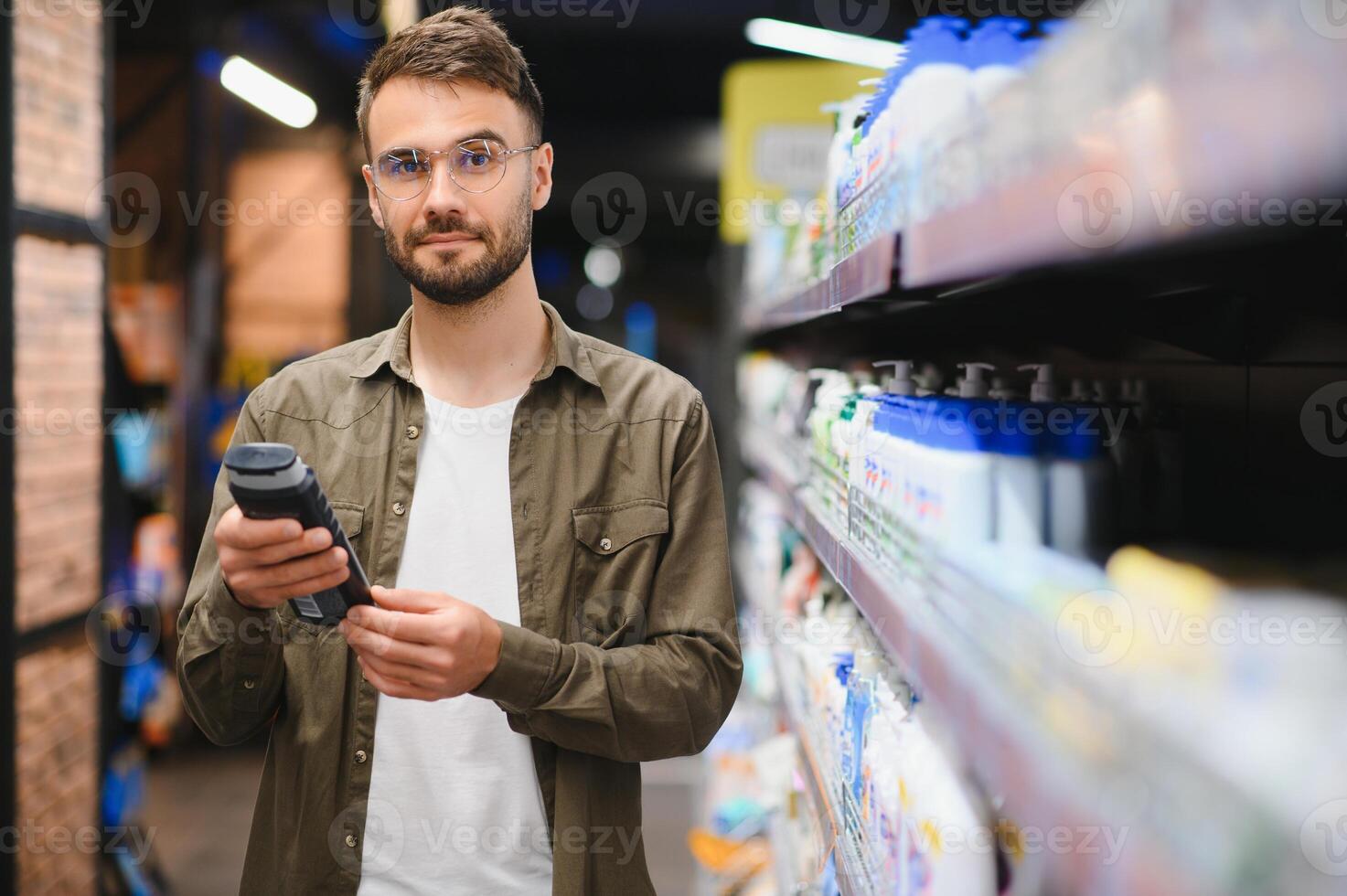 positief mannetje klant kiezen nieuw shampoo in supermarkt haar- sectie foto