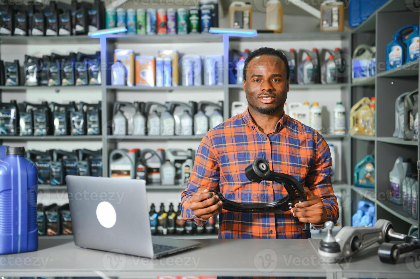 glimlachen Afrikaanse verkoper auto onderdelen op te slaan foto