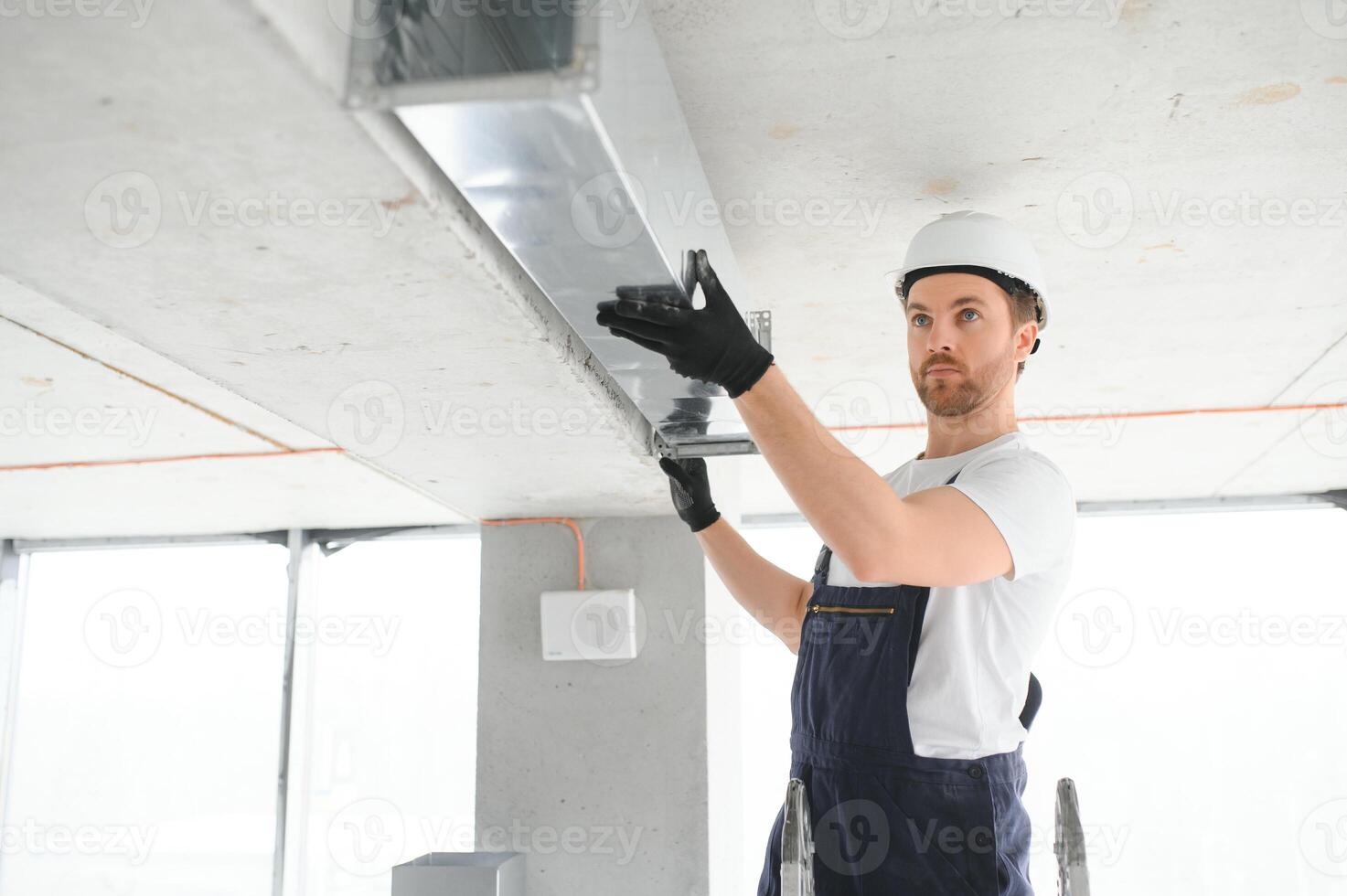 industrieel thema. magazijn verwarming en koeling systeem installatie door professioneel Kaukasisch technicus. reclame gebouw ventilatie rechthoek grachten. lucht verdeling. foto