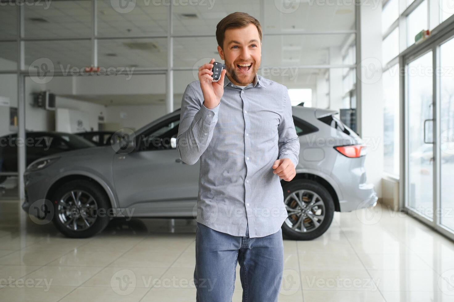 een Mens kiest een nieuw auto voor zichzelf wandelingen tussen de rijen in een auto handel foto