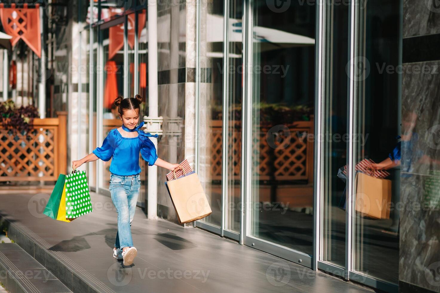 portret van mooi glimlachen weinig meisje vervelend met boodschappen doen zak buitenshuis foto