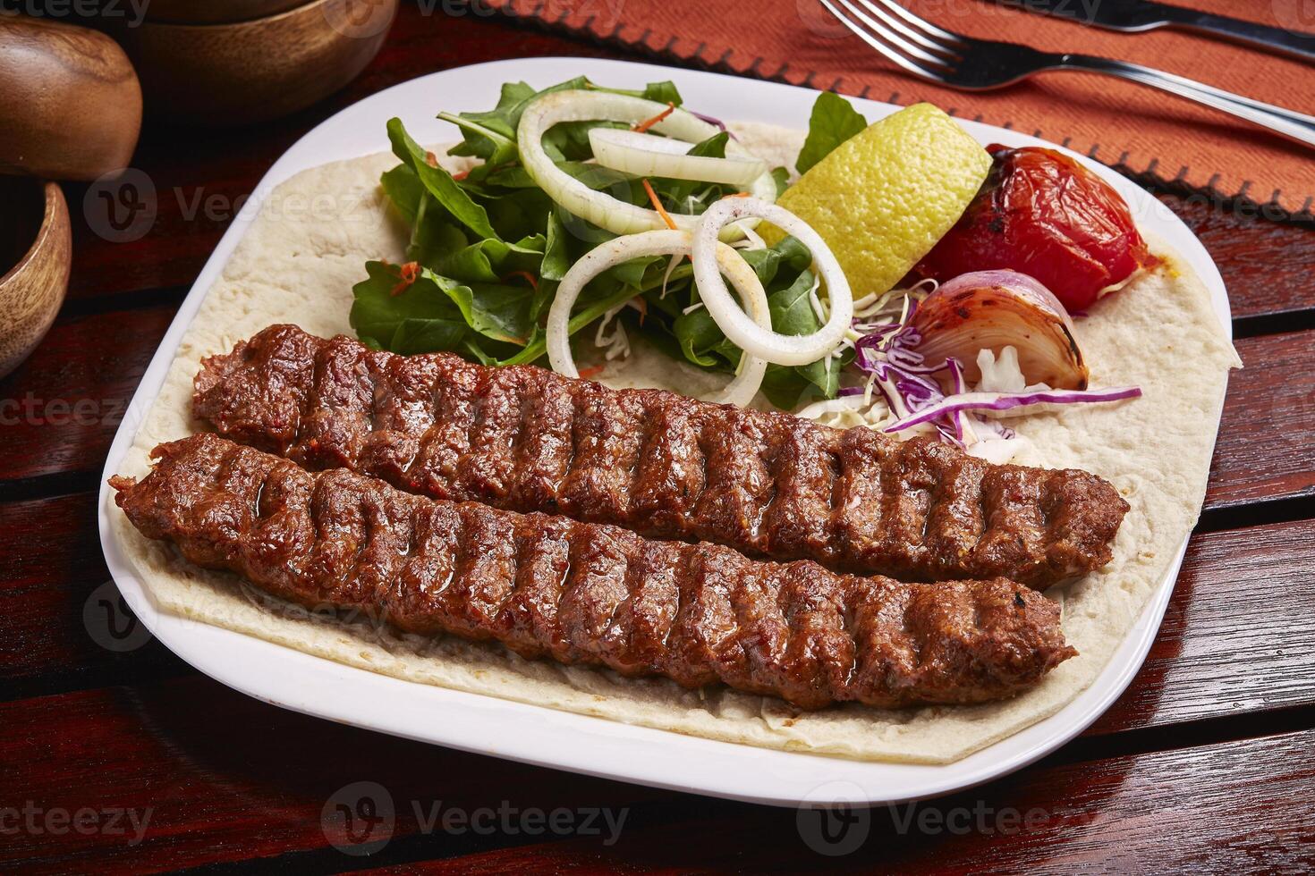 pittig bbq tandoori lam kabab met brood, limoen en salade geserveerd in schotel geïsoleerd Aan tafel kant visie van midden- oosten- voedsel foto