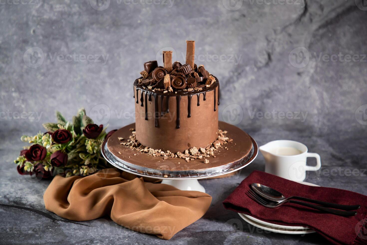 chocola overbelast taart met roos bloemen, mes en vork geserveerd Aan bord geïsoleerd Aan servet kant visie van cafe gebakken voedsel foto