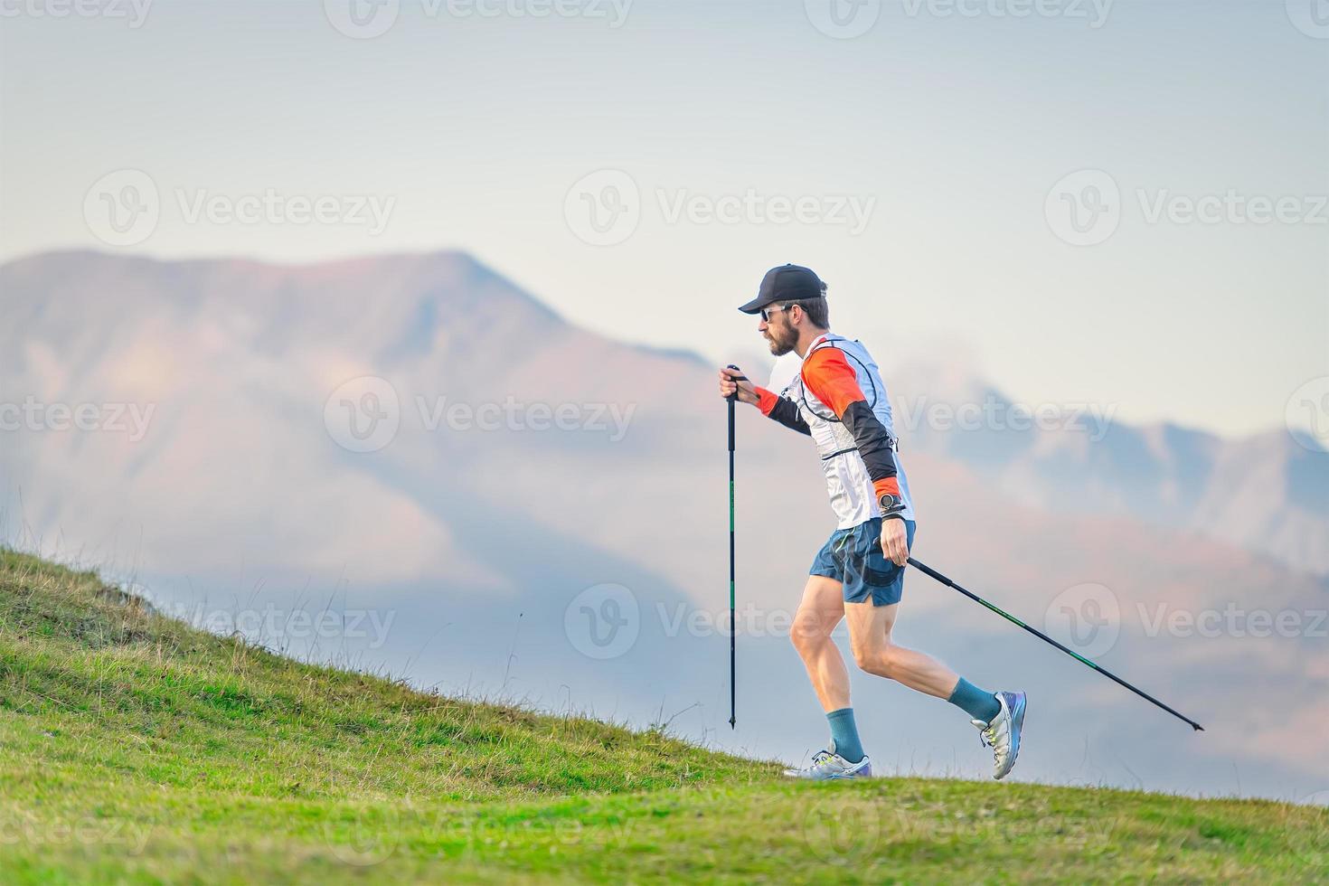 atleet die nordic walking beoefent in de heuvels foto