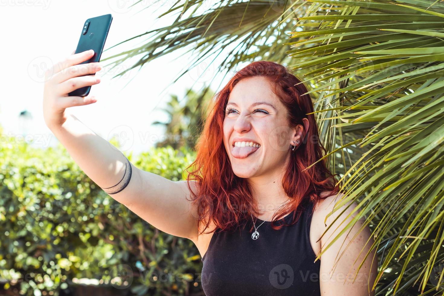 Kaukasische vrouw die een selfie met smartphone buiten in park neemt foto