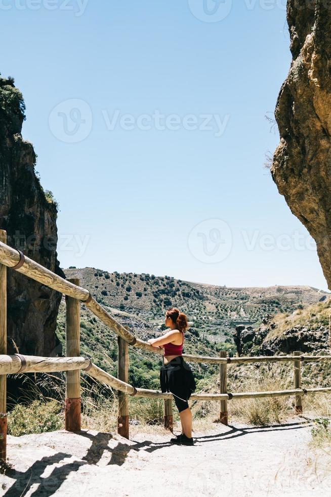jonge vrouw overweegt het landschap in los cahorros, granada, spanje foto
