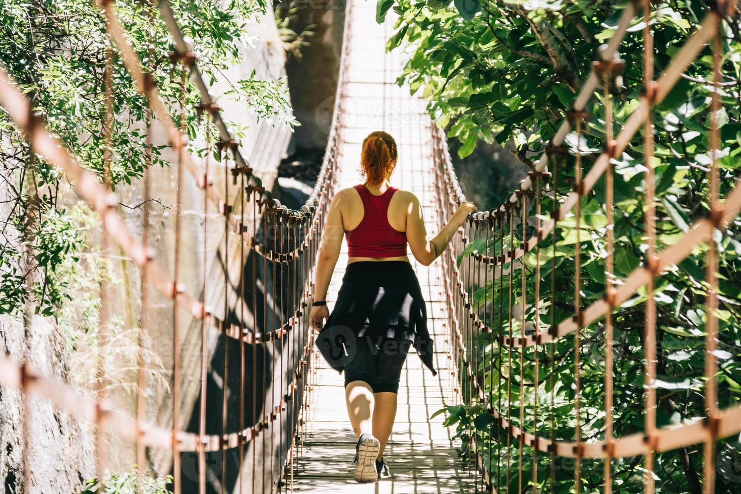 jonge vrouw op een hangbrug die op de los cahorros-route loopt, granada, spanje foto