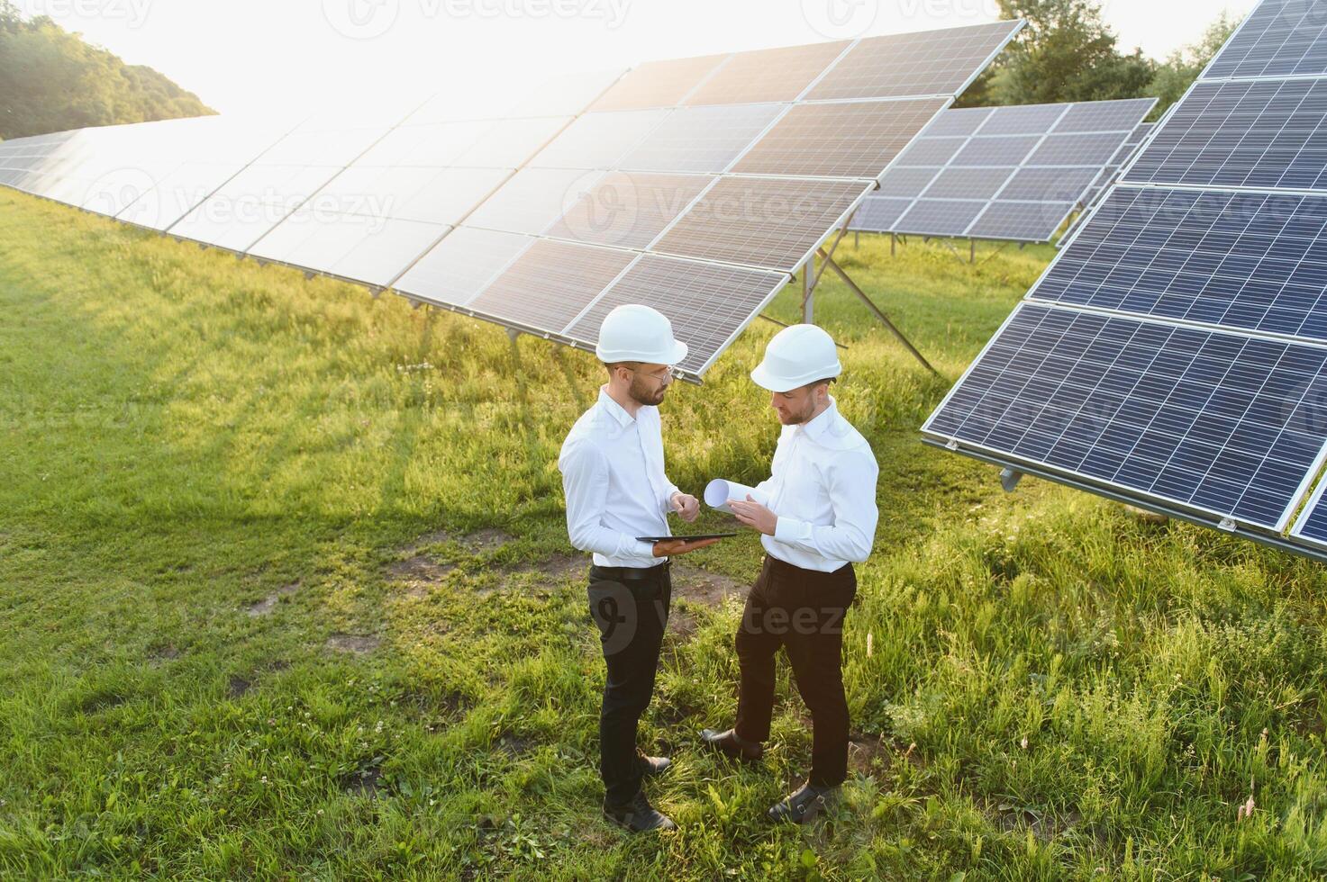 de zonne- boerderij zonne- paneel met twee ingenieurs wandelen naar controleren de operatie van de systeem, alternatief energie naar behouden de s werelds energie, fotovoltaïsche module idee voor schoon energie productie foto