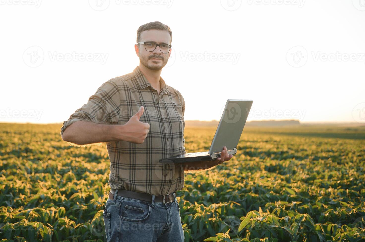 agronoom inspecteren soja Boon gewassen groeit in de boerderij veld. landbouw productie concept. jong agronoom onderzoekt soja Bijsnijden Aan veld- in zomer. boer Aan soja veld- foto