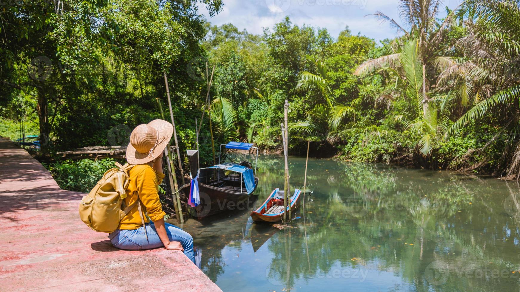 aziatische vrouw reizen natuur. reizen relax.a boot foto. zittend kijken naar de prachtige natuur bij tha pom-klong-song-nam. Krabi, in Thailand. foto