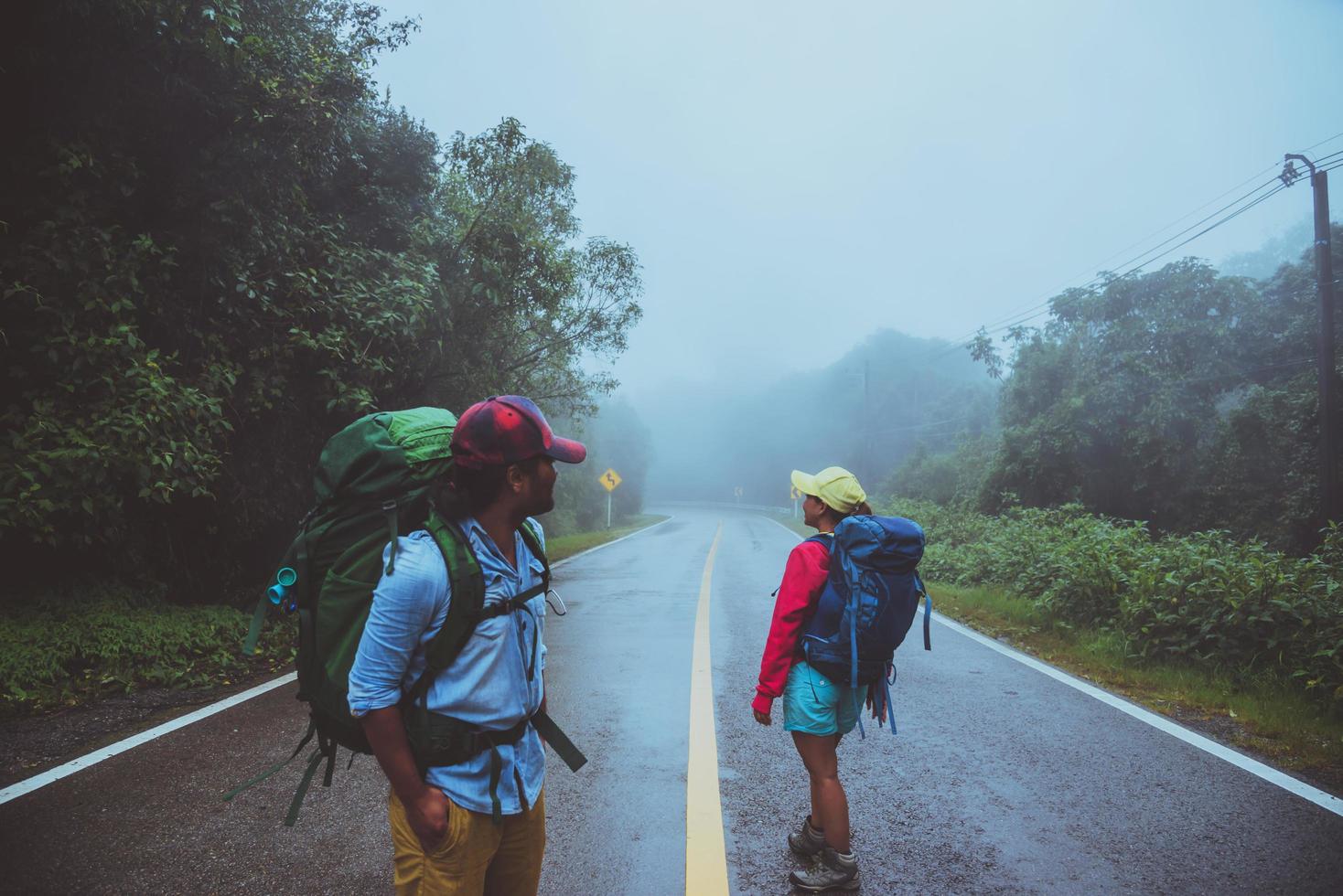 minnaar aziatische man en aziatische vrouwen reizen de natuur. lopen op de weg route. de natuur gelukkig reizen. te midden van de mist regenachtig. foto