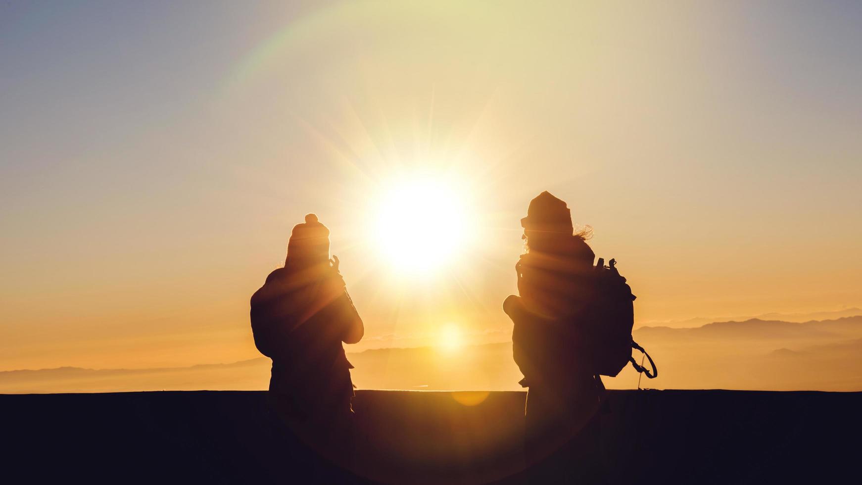 minnaar vrouwen en mannen aziatische reizen natuur. reizen ontspannen. natuurlijk tintje platteland. op de berg. staan kijken naar de zon opkomen. Thailand foto