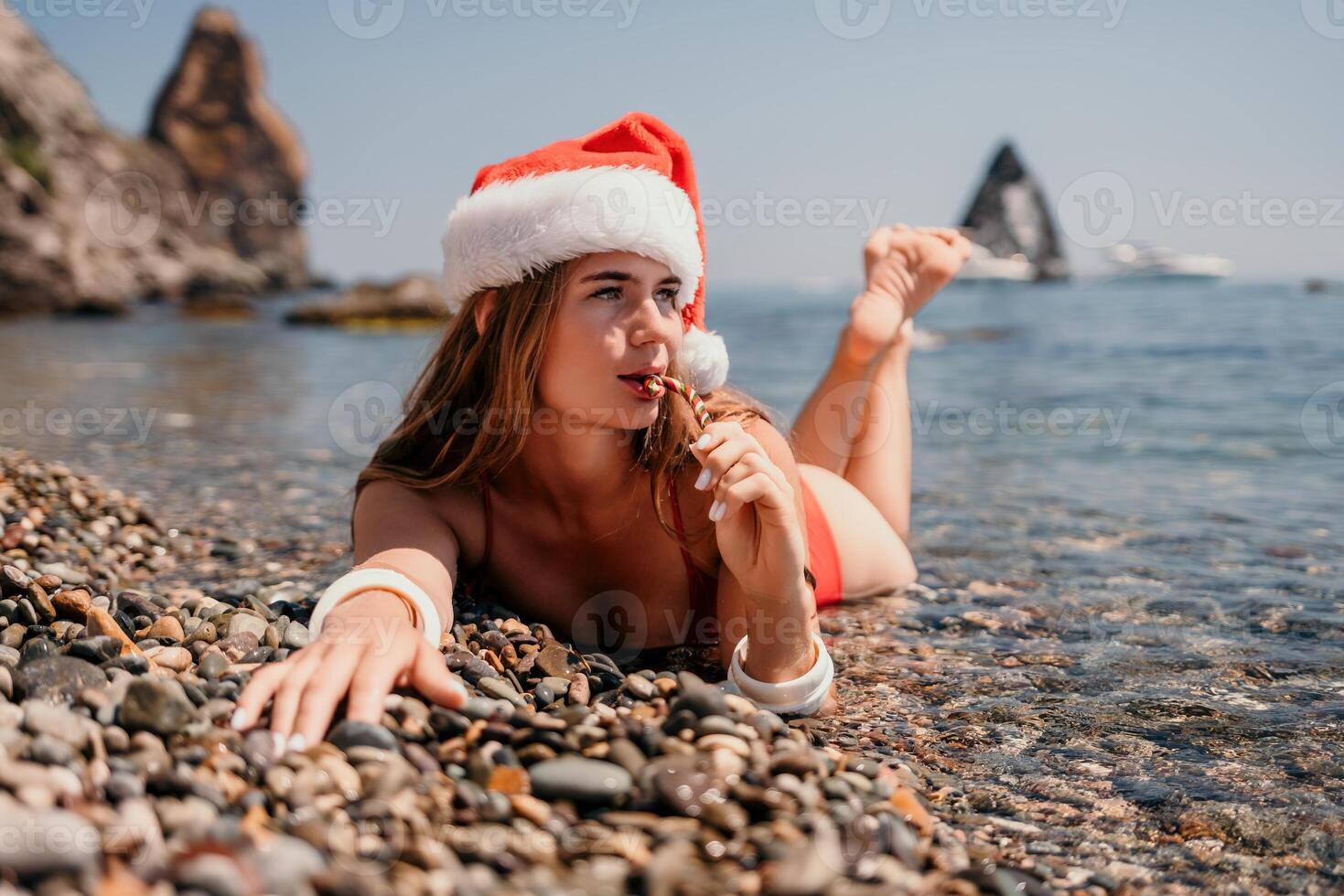 vrouw reizen zee. gelukkig toerist genieten nemen afbeelding Aan de strand voor herinneringen. vrouw reiziger in de kerstman hoed looks Bij camera Aan de zee baai, sharing reizen avontuur reis foto