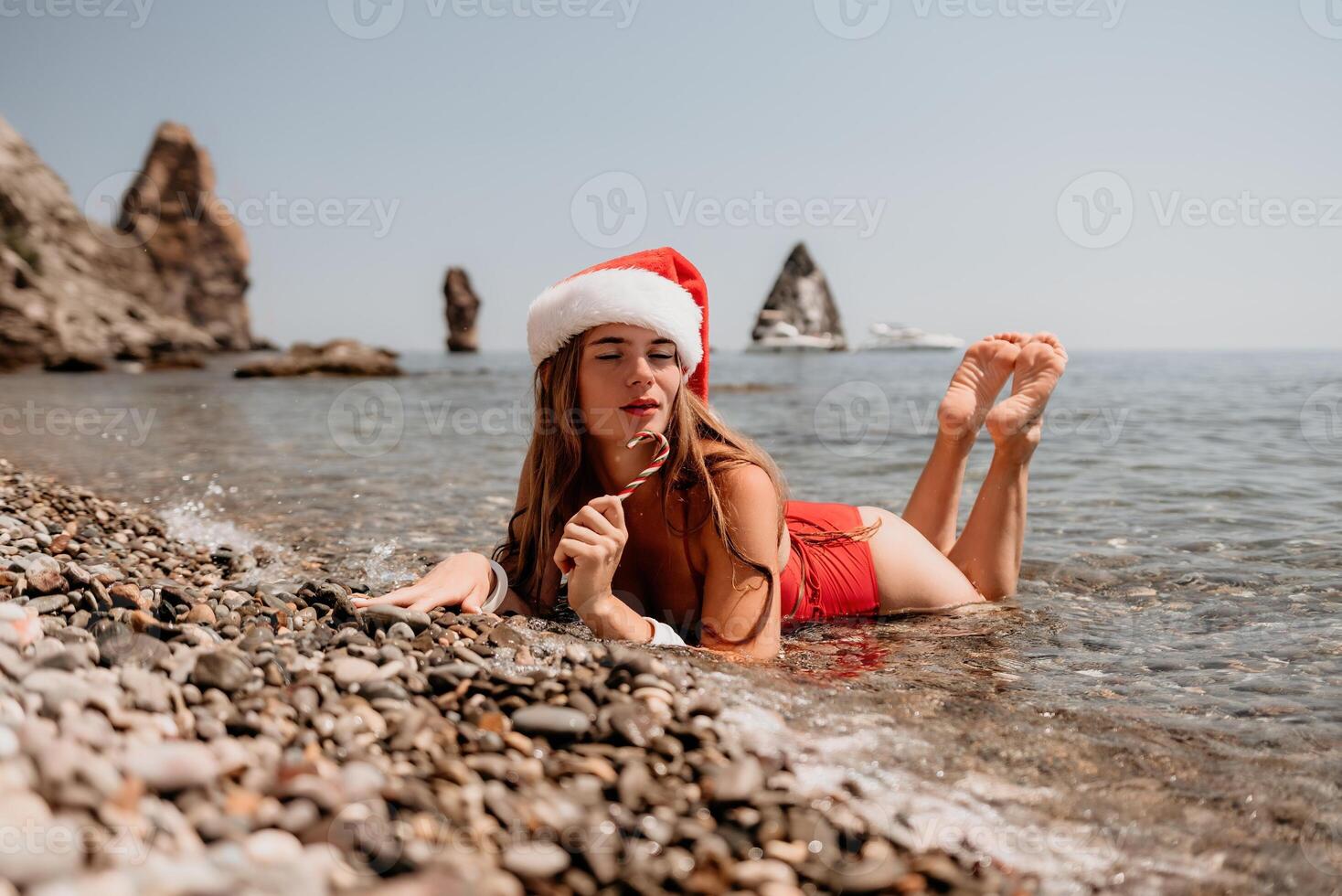 vrouw reizen zee. gelukkig toerist genieten nemen afbeelding Aan de strand voor herinneringen. vrouw reiziger in de kerstman hoed looks Bij camera Aan de zee baai, sharing reizen avontuur reis foto