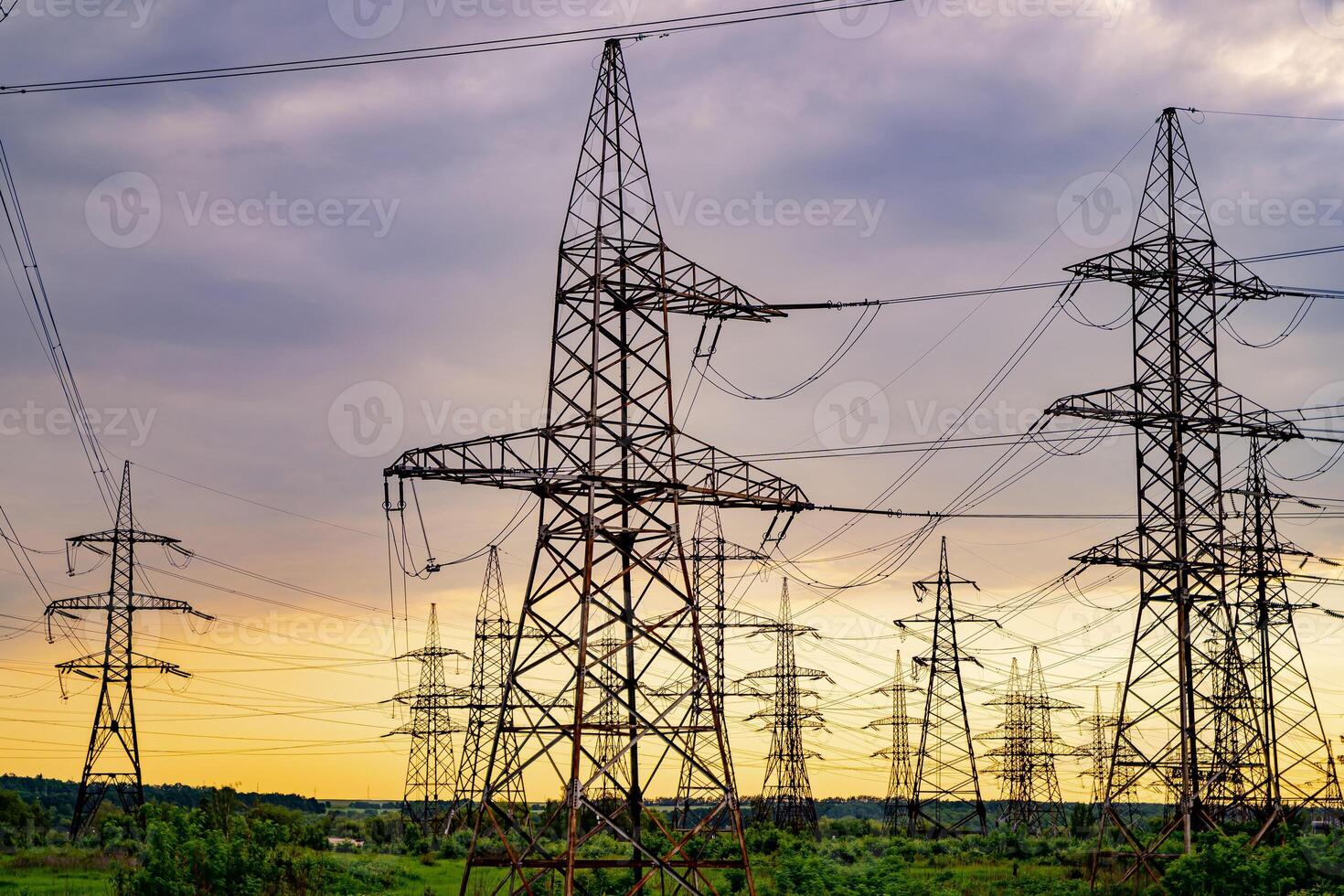 elektriciteit pylonen en hoog voltage macht lijnen Aan de groen gras. macht fabriek. elektrisch macht rooster. visie van onderstaand. foto
