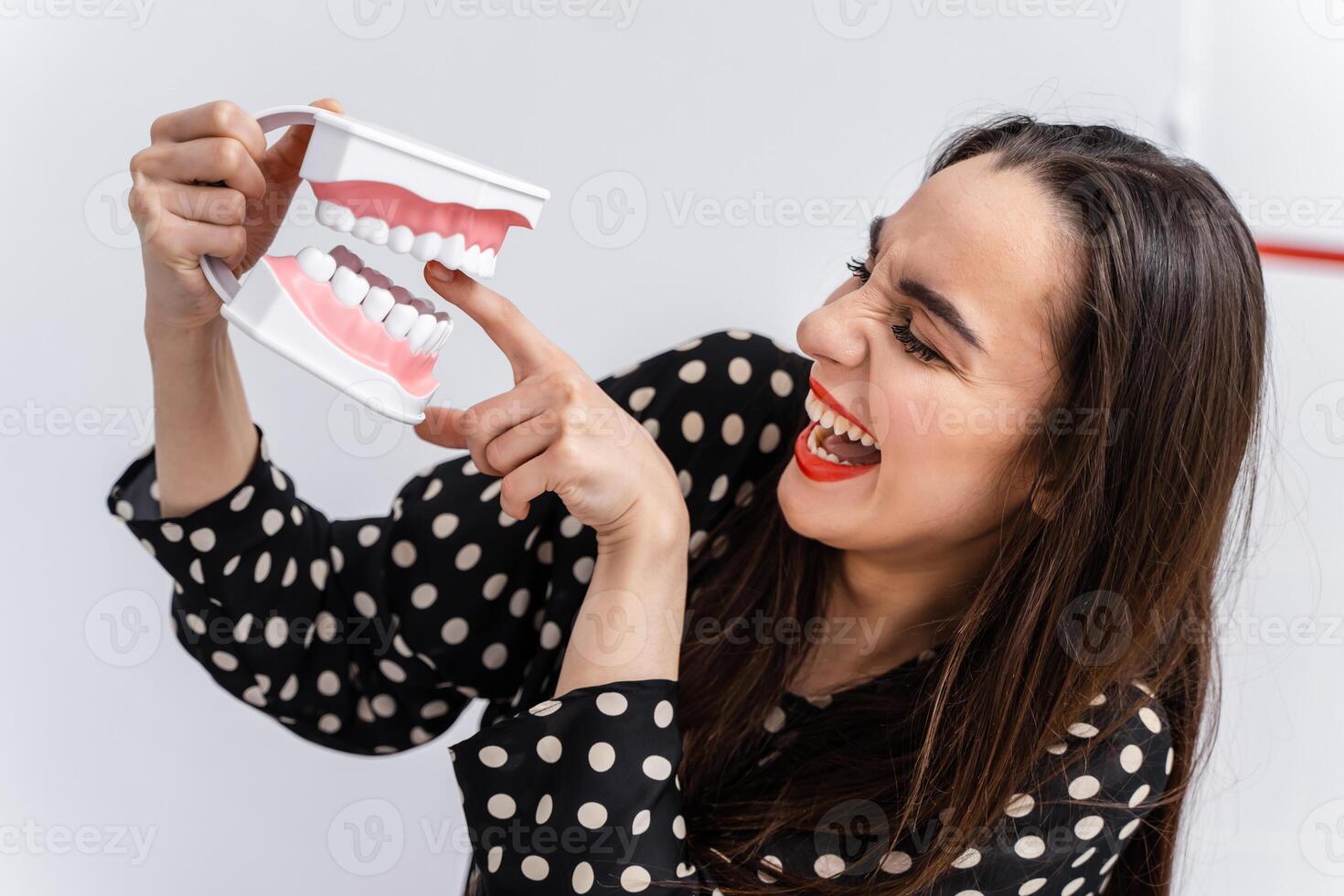 meisje zetten vinger naar een tandheelkundig leerzaam kaak. plastic kaak bijt een meisje door een vinger. grappig emoties. foto