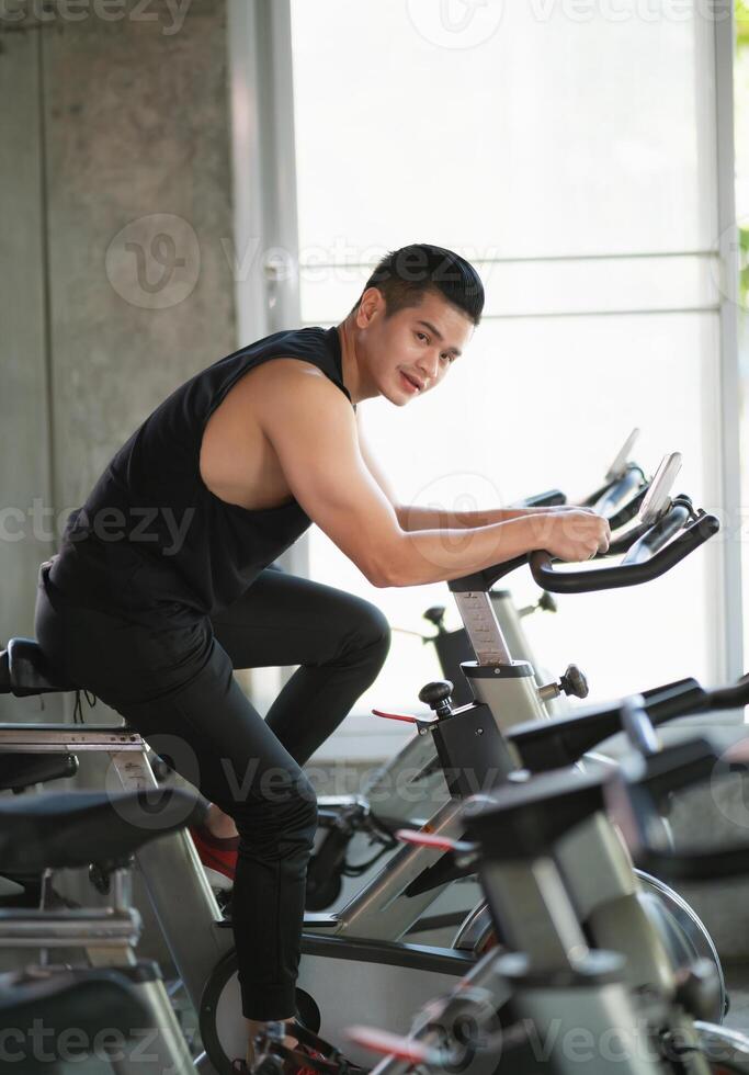 Aziatisch sportman oefenen Aan een fiets in de Sportschool, bepaling naar cardio verliezen gewicht, maakt haar gezond. oefening fiets Mens geschiktheid sport concept. foto