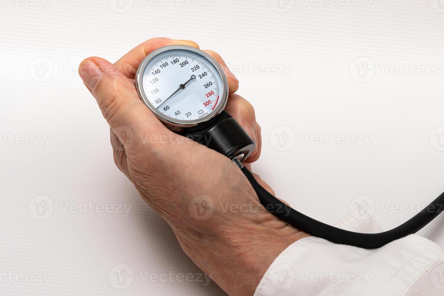 de dokter hand- houdt een manometer van een apparaat voor meten bloed druk. foto