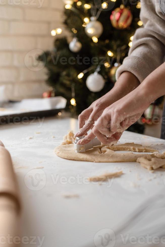 lachende vrouw in de keuken die kerstkoekjes bakt foto
