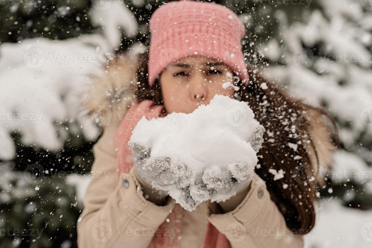 close-up van brunette vrouw die sneeuw blaast foto