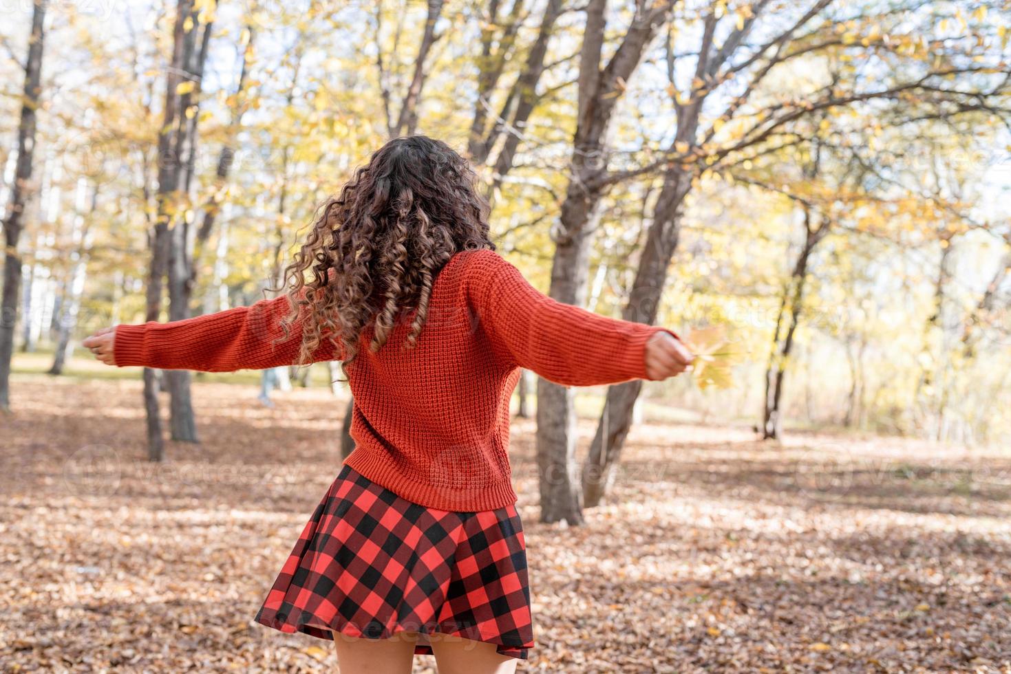 jonge gelukkige vrouw die in de herfstbos loopt foto