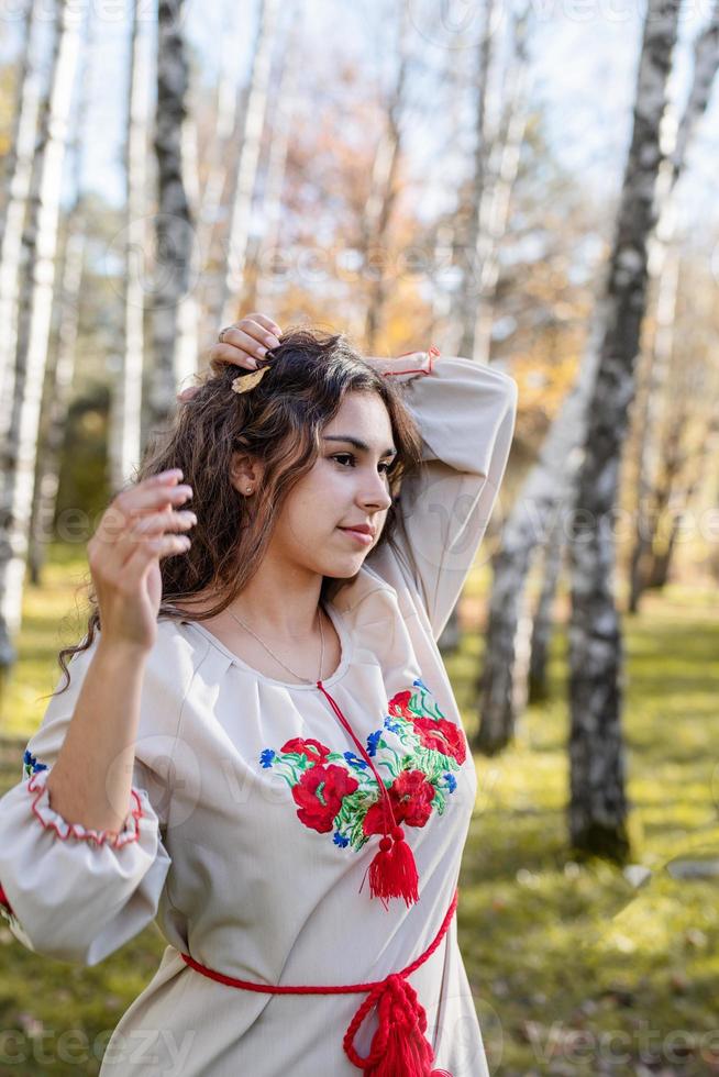 mooie vrouw in Oekraïense nationale traditionele kostuumkleren in bos foto