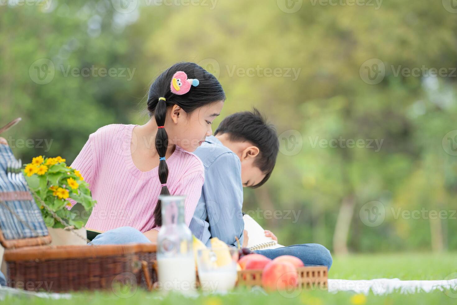 gelukkig familie genieten van een picknick in de park, kinderen zittend terug naar terug en lezing boeken. foto