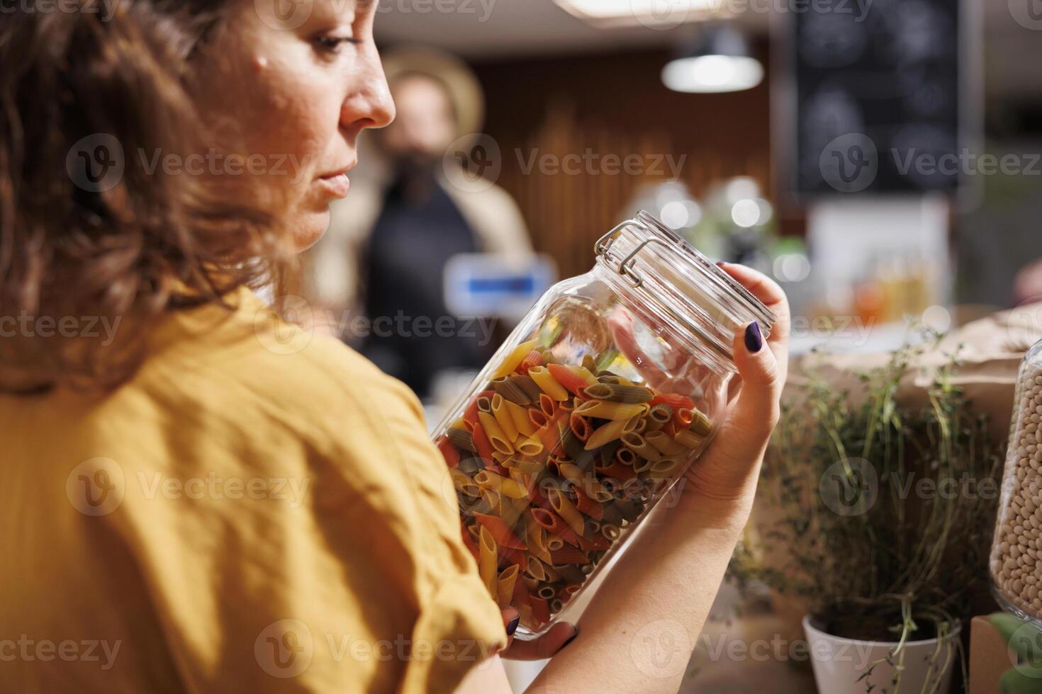 milieuvriendelijk bewust klant in nul verspilling bulk producten winkel op zoek voor eigengemaakt pasta. cliënt inkoop biologisch niet ggo voedsel in eco vriendelijk lokaal buurt supermarkt foto