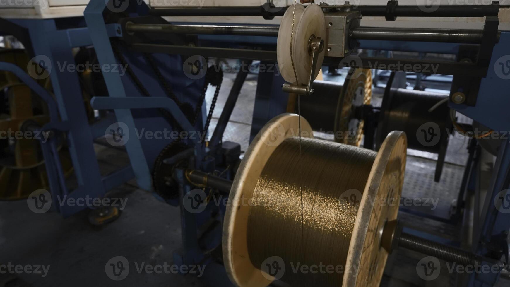 industrieel machine voor kronkelend koper draad Aan wikkelen. creatief. geautomatiseerd productie van metallurgisch fabriek met wervelende koper draden. kronkelend van koper draad Aan klossen van industrieel machine foto