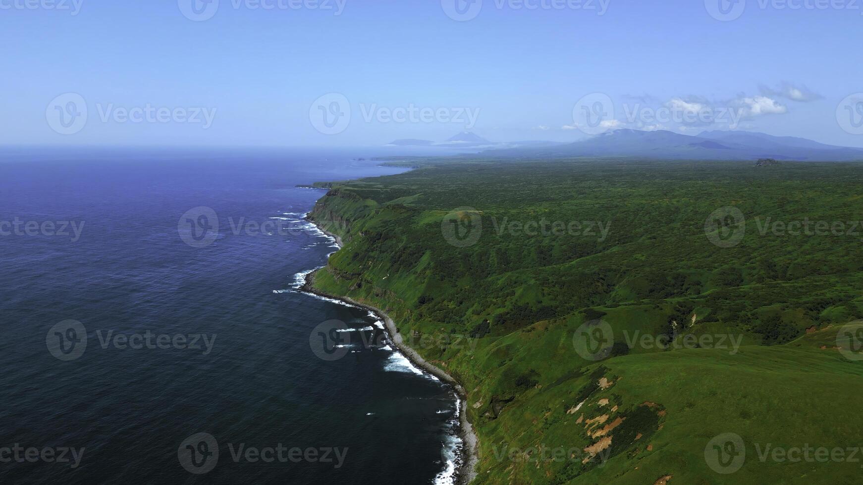 groen velden, weiden, zomer blauw lucht en kalmte zee. klem. pittoreske platteland marinier landschap met groen bebost kliffen. foto
