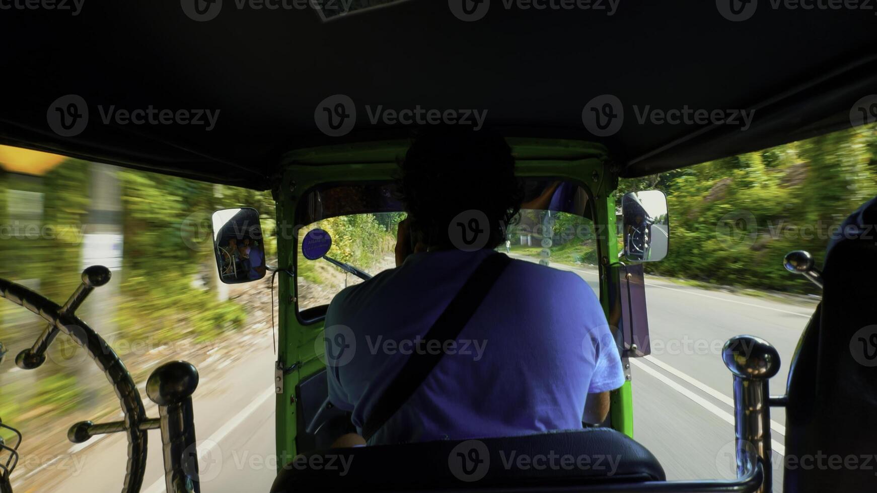 achterzijde visie van een tuktuk of motorfiets bestuurder draag- passagiers langs groen bomen en auto's. actie. concept van reizend. foto