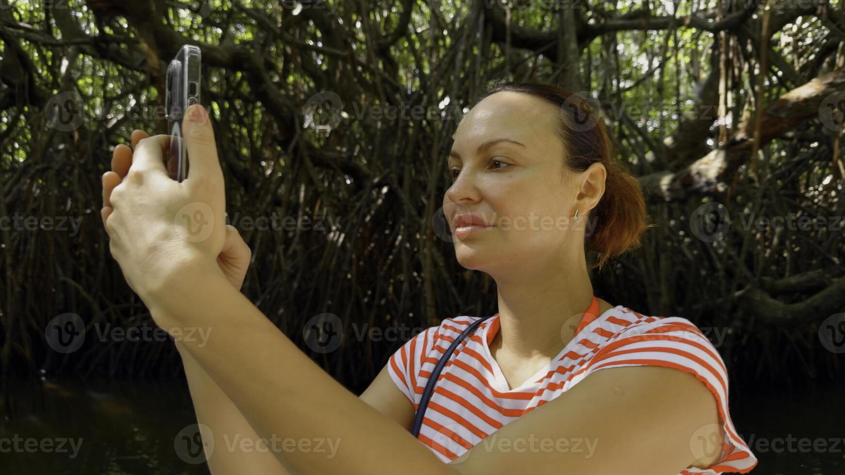 oerwoud reis naar beneden een moerassig rivier, costa rica. actie. portret van vrouw toerist maken afbeeldingen en videos van omgeving natuur. foto