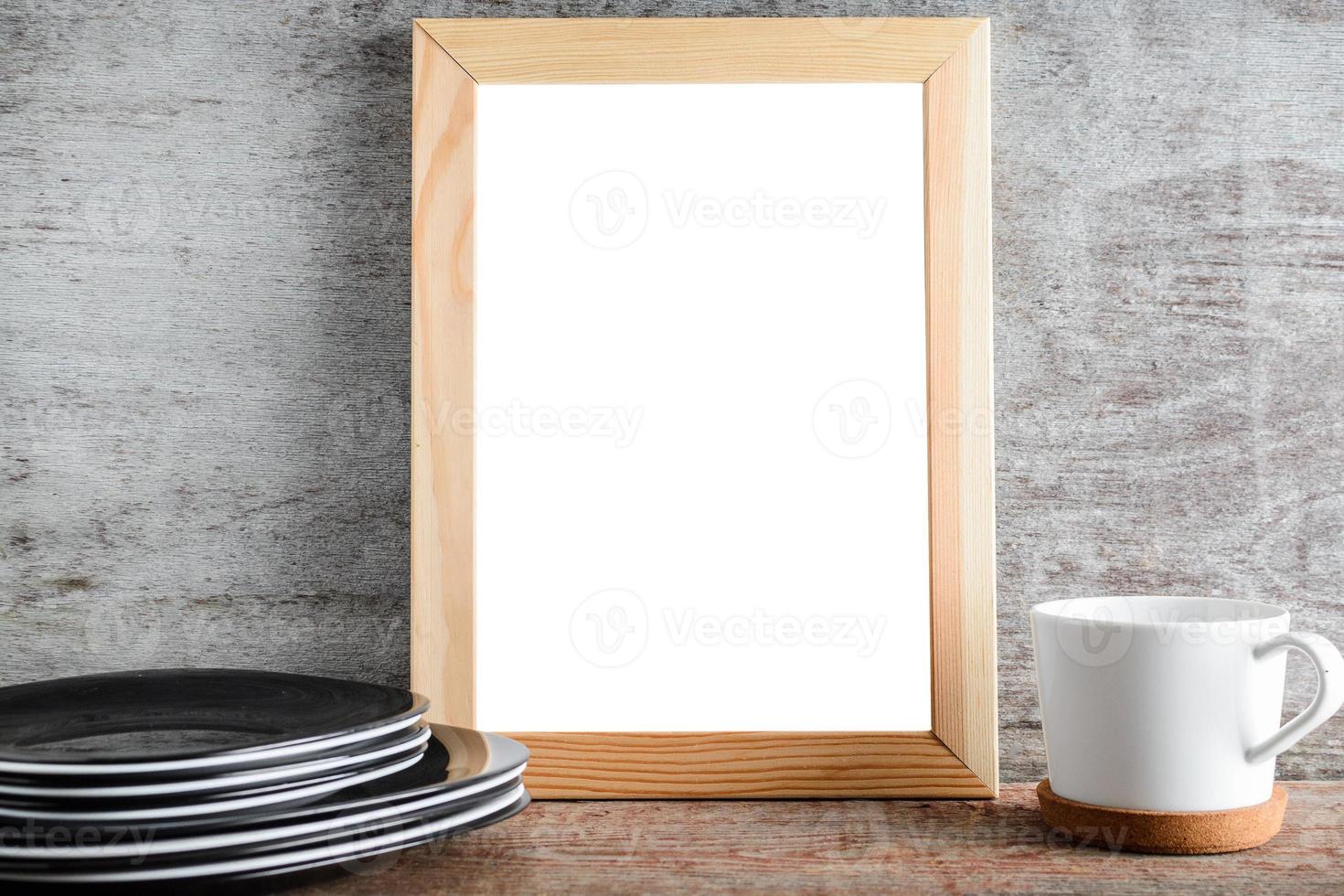 leeg houten frame en keukenaccessoires op tafel foto